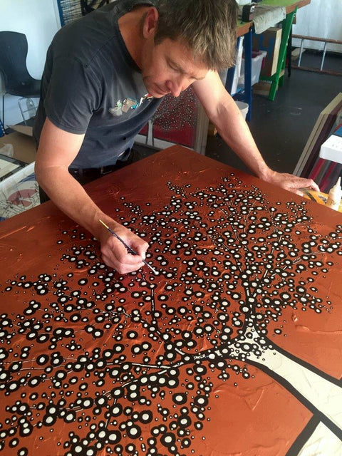 Das Bild zeigt den südafrikanischen Künstler Richard Scott wie er eines seiner Kunstwerke fertig stellt.