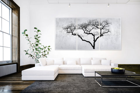 Druck auf gebürstetem Aluminium, Boom von der afrikanischen Künstlerin Linnea Frank in einem Wohnzimmer mit dunklem Boden über einem weißen Sofa, auf dem dreiteiligen Kunstwerk ist ein Baum zu sehen. 
