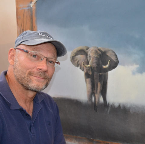 Foto des afrikanischen Künstlers Richard Scott beim Malen eines neuen Kunstwerks