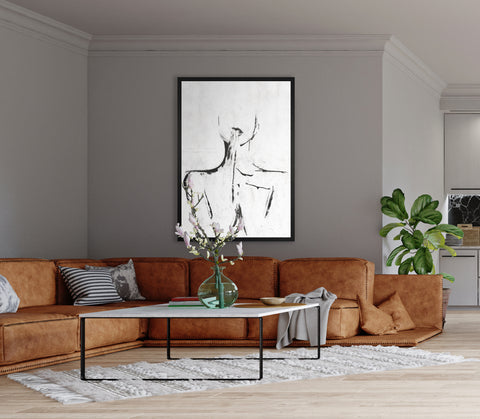 Druck auf schwarzem Metall, Horizon von der afrikanischen Künstlerin Linnea Frank in einem Wohnzimmer über einem braunen Sofa, auf dem Kunstwerk sind die Umrisse einer Frau zu sehen, die ihre Hände vor dem Körper zusammenführt