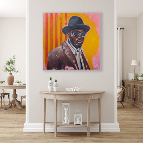 Gemälde, Acryl auf Leinwand, „The Tycoon“ vom afrikanischen Künstler Khaya Sineyile in einem hell gehaltenen Raum über einem kleinen Holztisch, auf dem Kunstwerk ist ein Mann mit Hut und Sonnenbrille vor einem comicartigen gelben und pinken Hintergrund mit orangenen Streifen zu sehen.