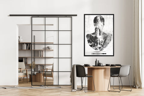 Druck auf schwarzem Dibond-Metall, Lacuna Invert Nummer 6 von 7 von der afrikanischen Künstlerin Linnea Frank in einem Zimmer über dem Esstisch, auf dem Kunstwerk ist eine Frau in schwarz und weiß zu sehen, die ihre Arme und Handflächen vor dem Gesicht und Oberkörper zusammengeführt hat 